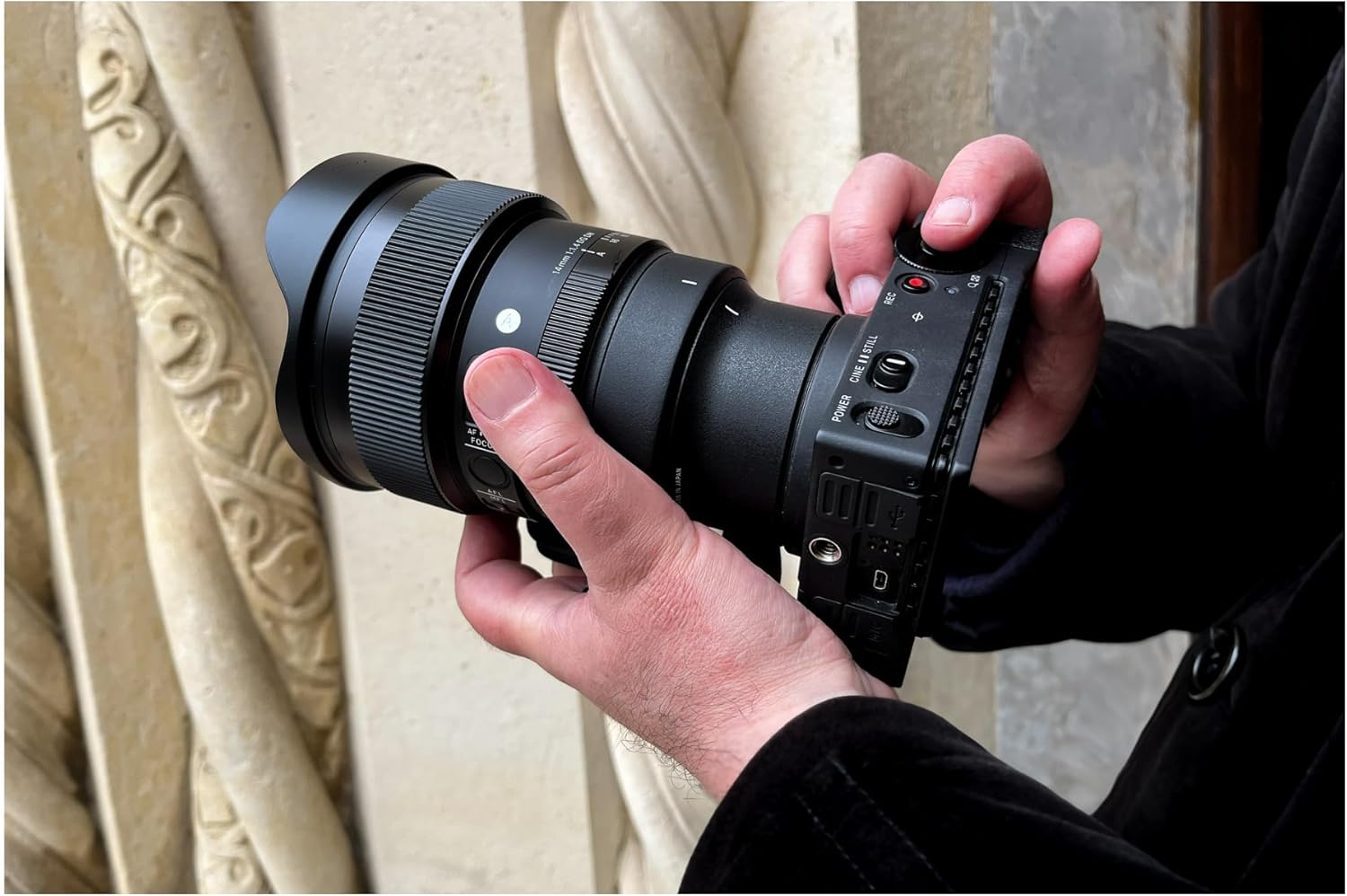 Hands attaching Sigma 14MM F1.4 DG DN A lens to a camera body