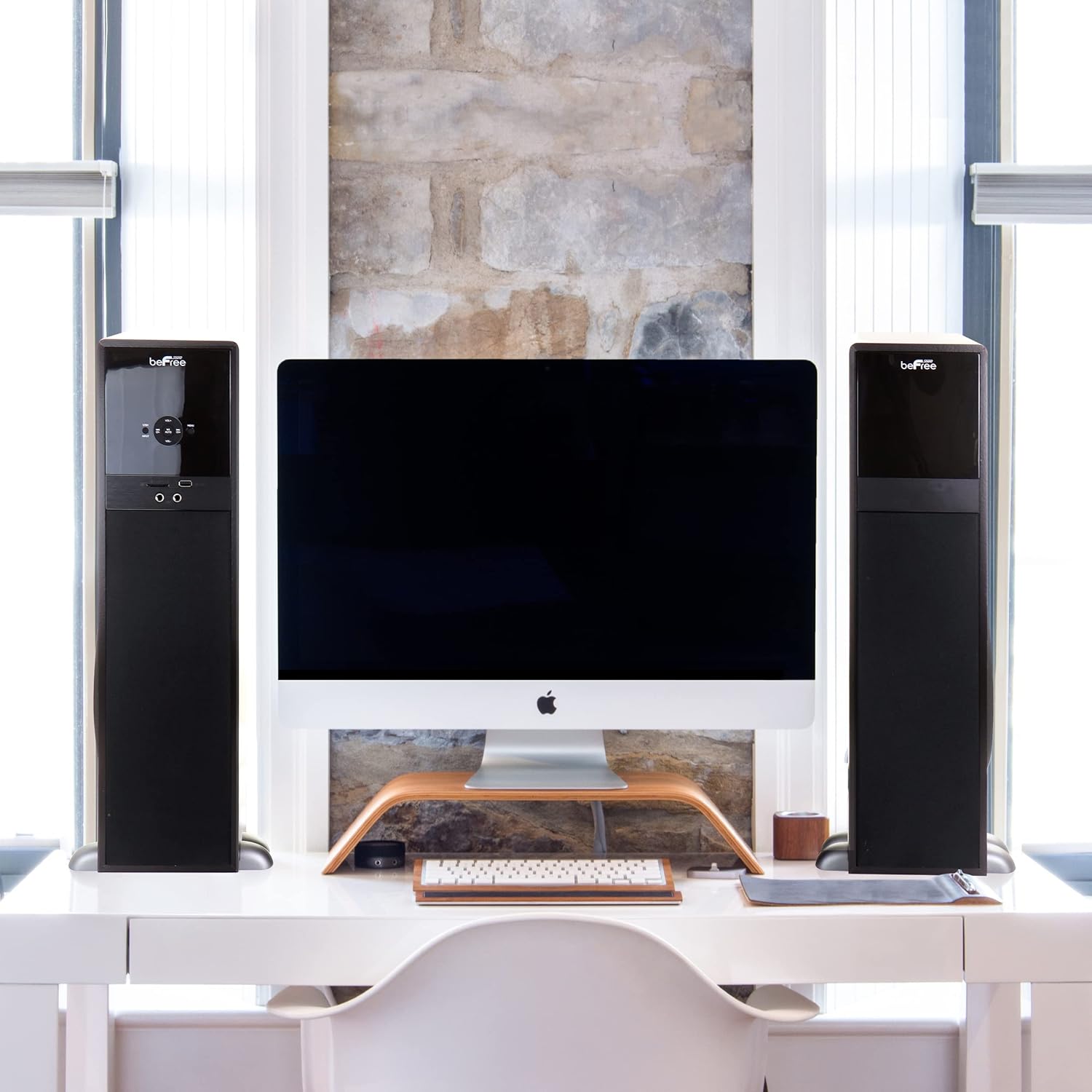 beFree Sound tower speakers positioned on a desk next to a computer monitor.
