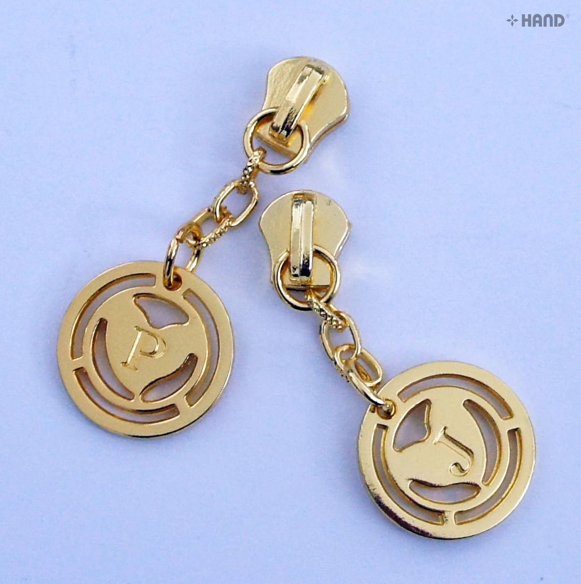 Two individual gold zip pulls with P and J charms