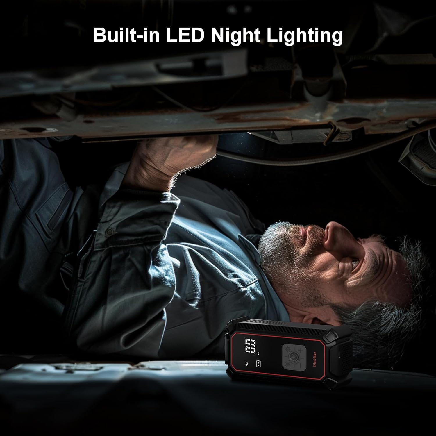 Mechanic using the OlarHike tire inflator's built-in LED light in a dark environment.