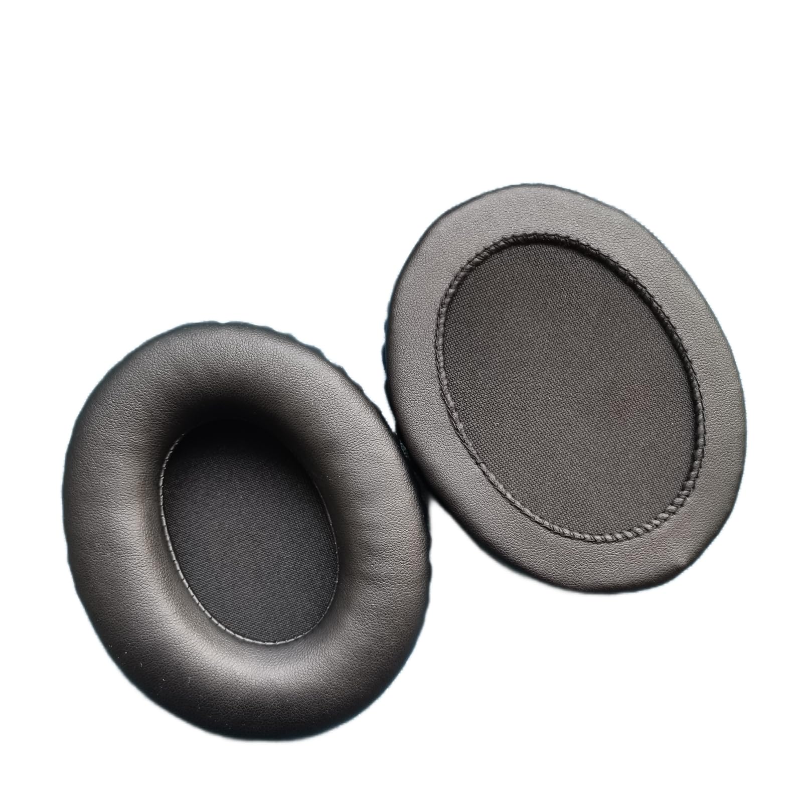 Two black replacement ear pads, one showing the front soft leather surface and the other flipped to show the rear attachment ring and mesh.