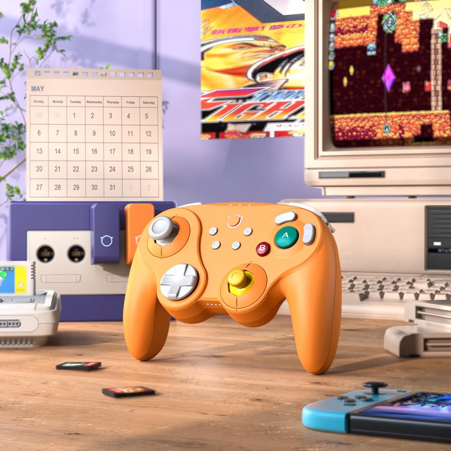 Orange NYXI Warrior controller on a desk with a retro gaming setup, including a Nintendo GameCube and an old CRT monitor.