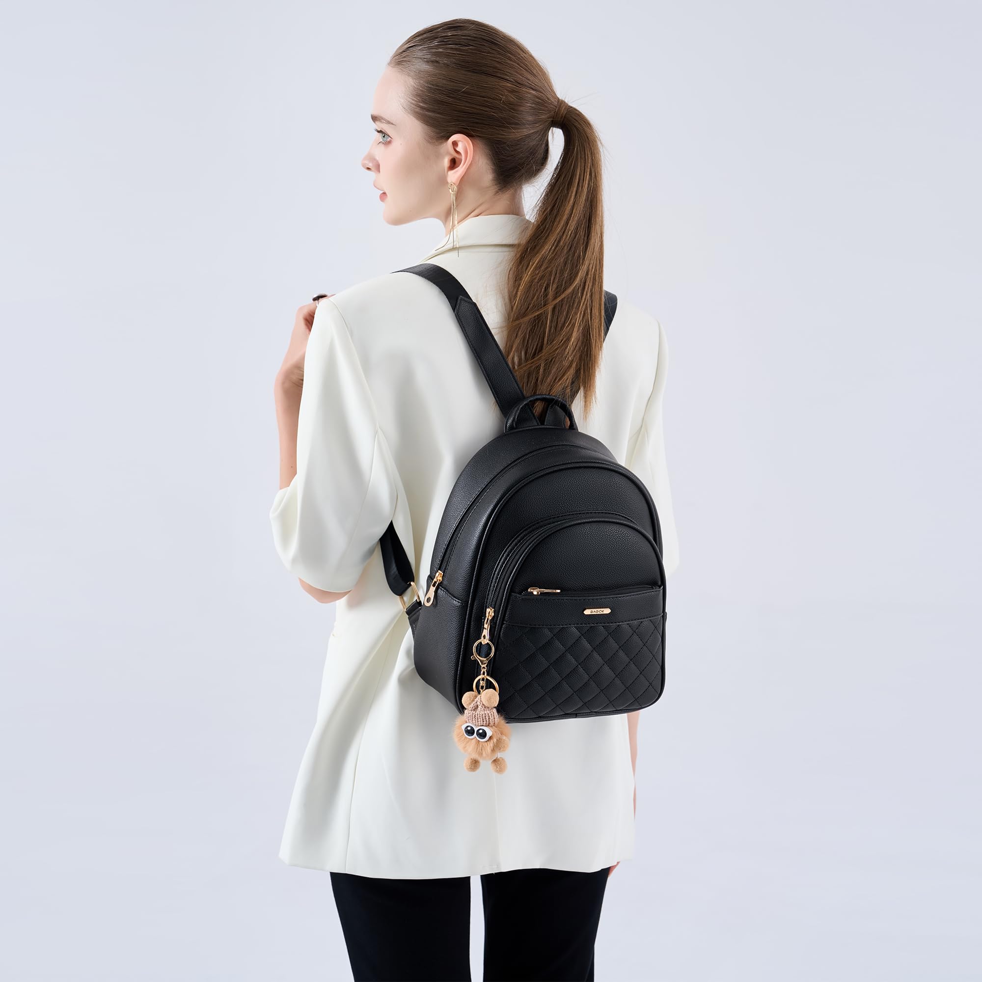 BAGOK Mini Rucksack Damen Klein – Eleganter Kunstleder Rucksack mit Steppoptik, Plüschanhänger & Quaste – Für Frauen & Mädchen im Alltag & auf Reisen(Schwarz)