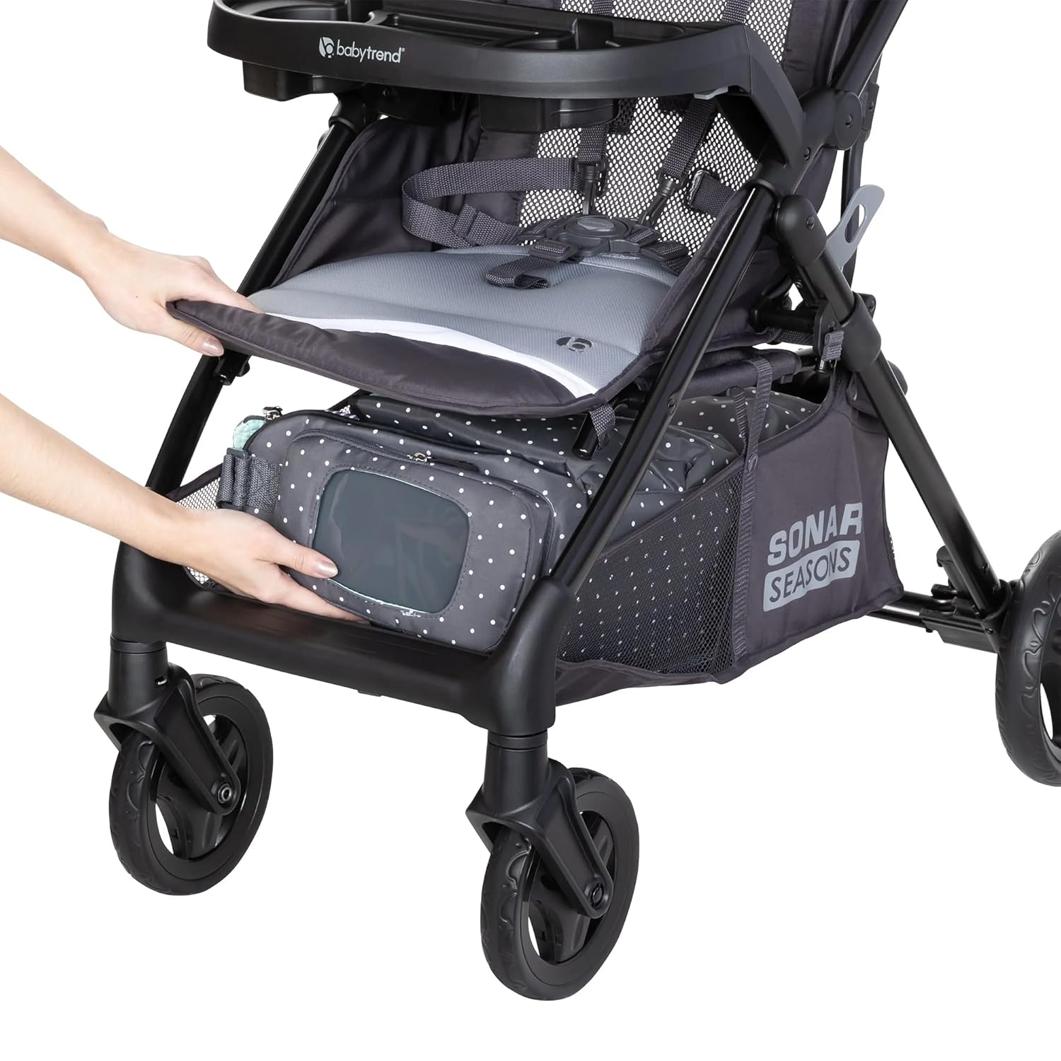A person accessing the storage basket of the Baby Trend Sonar Seasons Stroller from the front