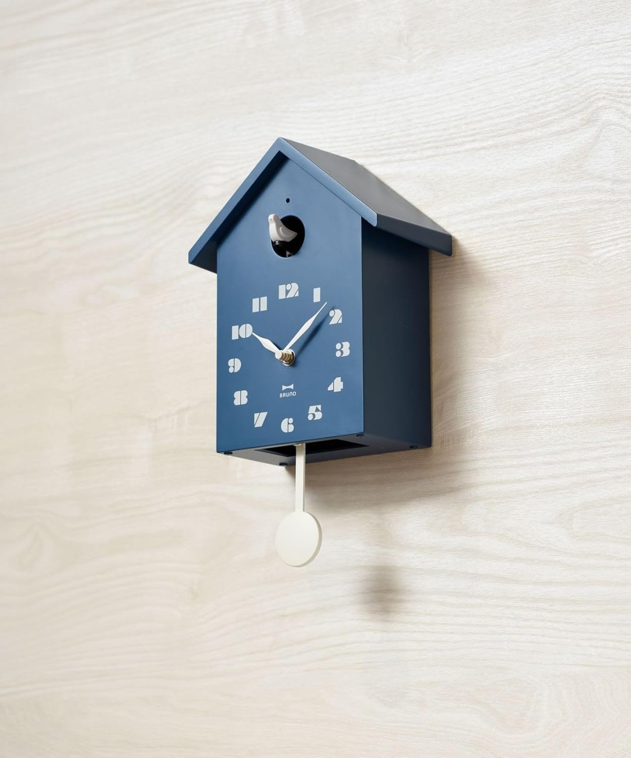 BRUNO Cuckoo Clock in blue, mounted on a light wooden wall.
