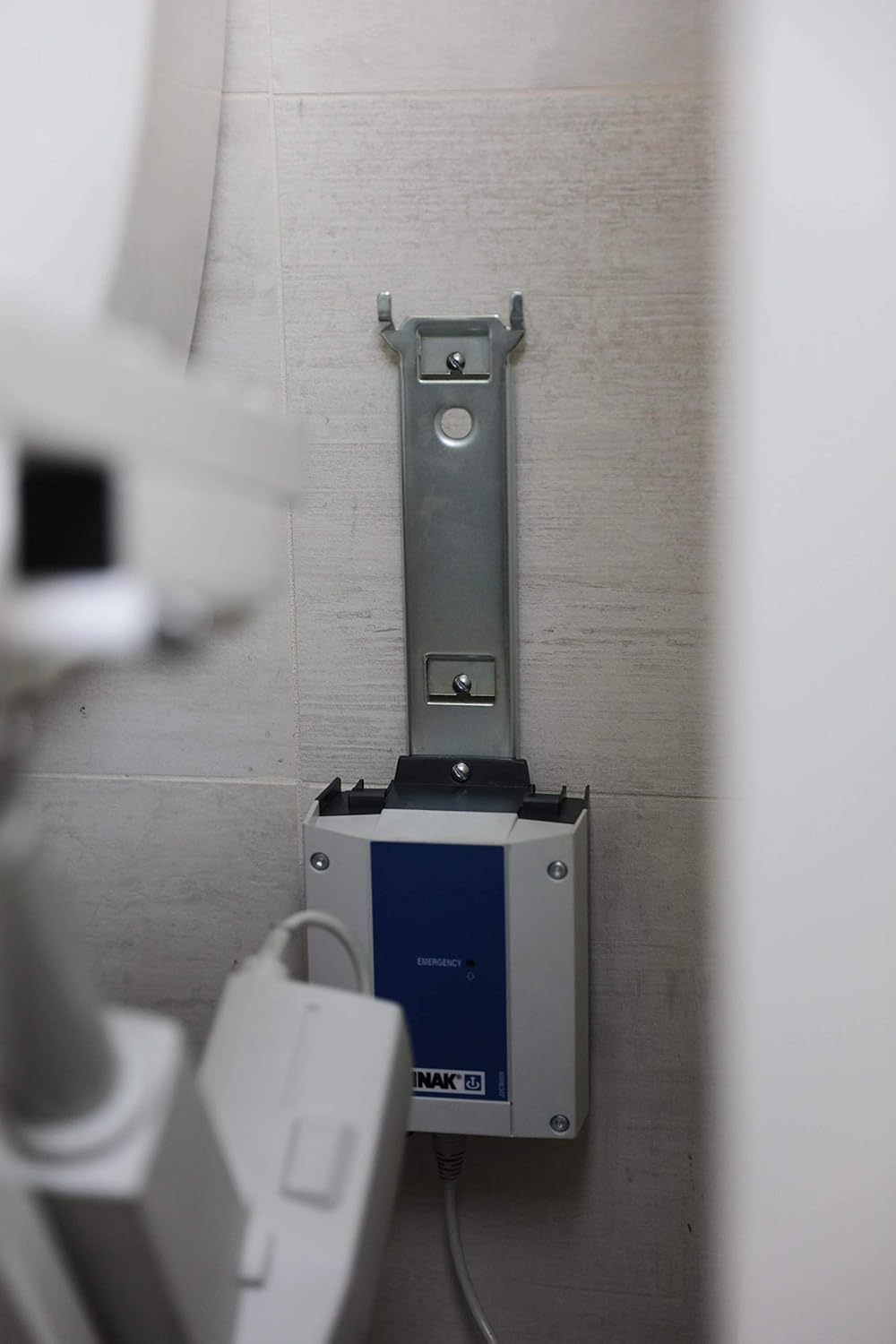 Close-up of the wall mount bracket for the TILT toilet lift's battery pack.