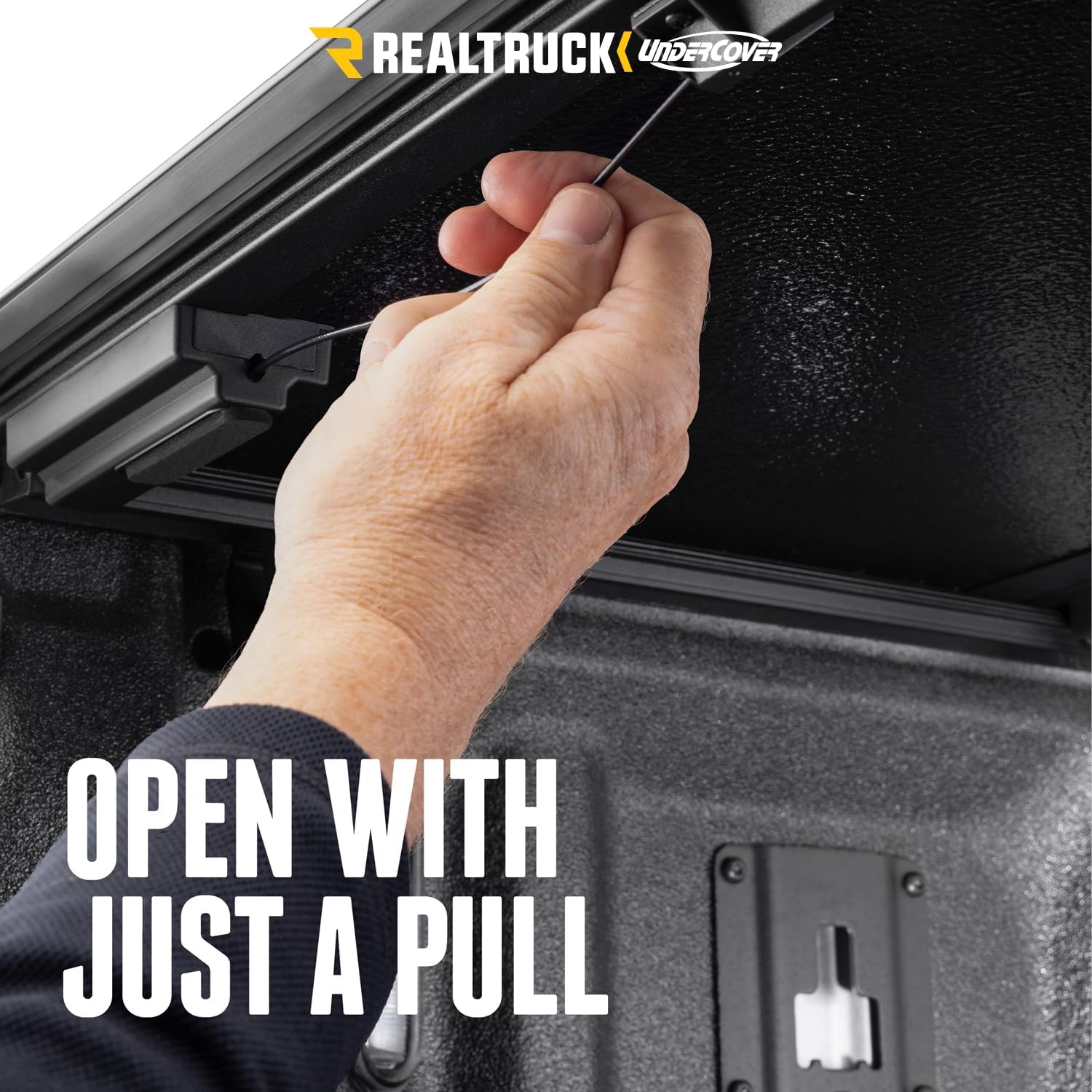 Hand pulling release cable to open tonneau cover