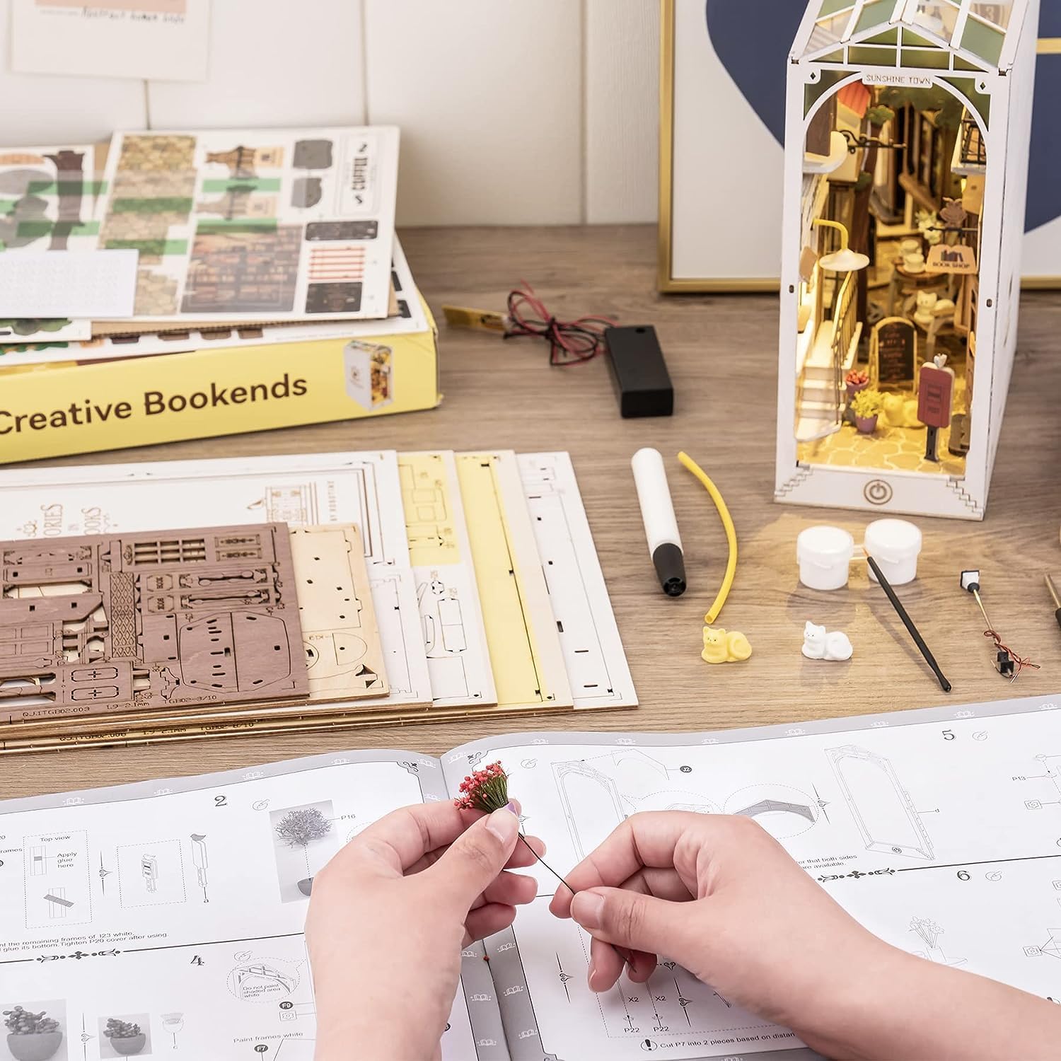 Hands attaching a miniature plant to its base.
