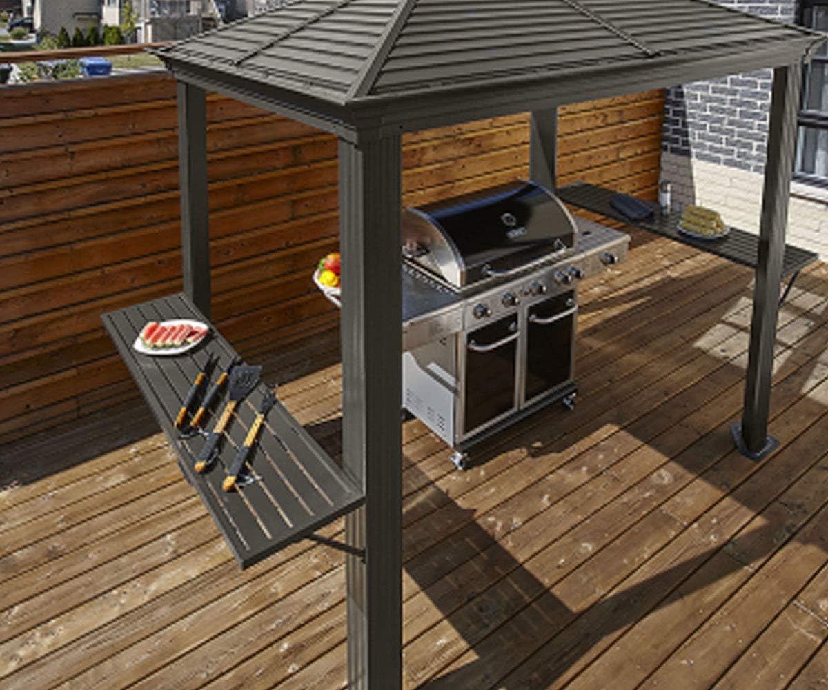 Assembled Sojag Mykonos BBQ Grill Gazebo on a wooden deck with a grill and food on shelves.