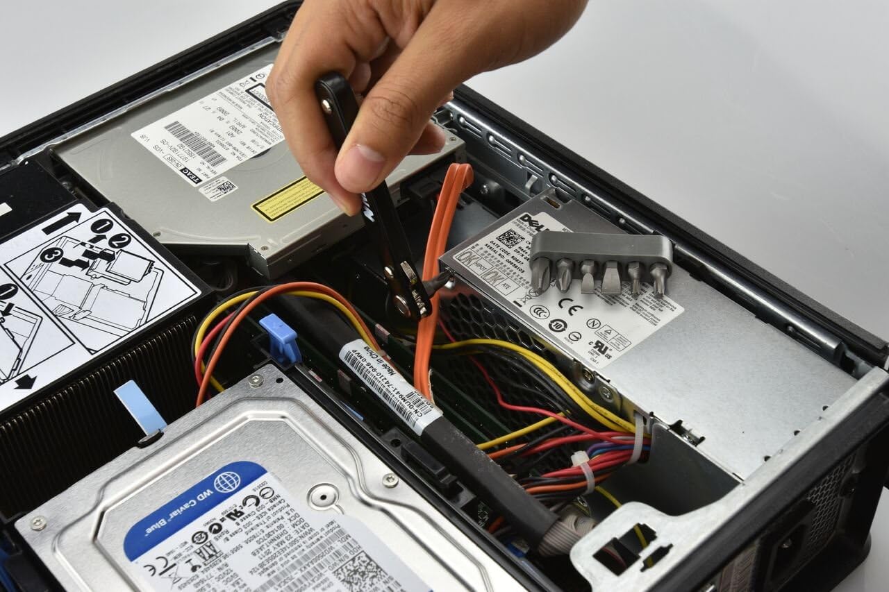 Hand using the mini ratchet screwdriver inside a computer case