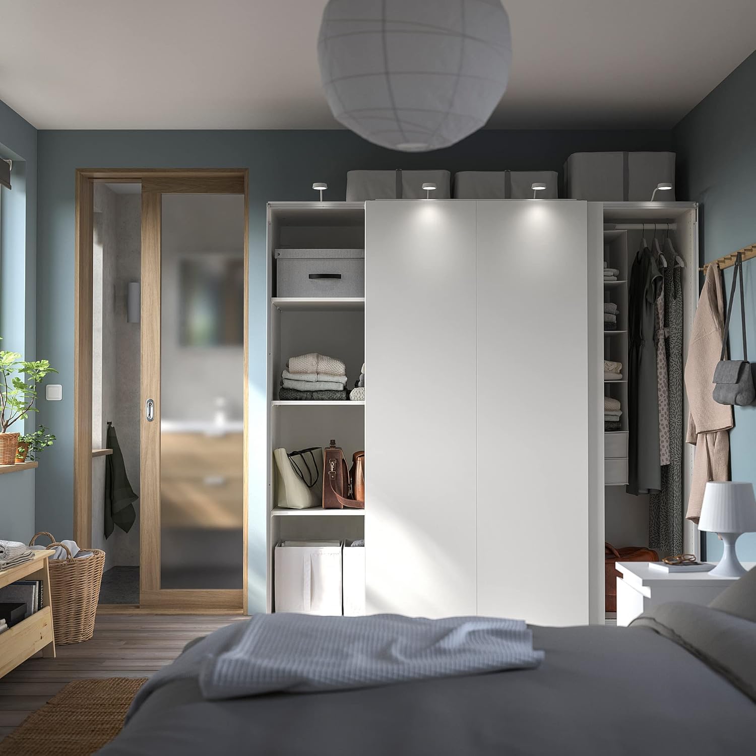 IKEA PAX/HASVIK wardrobe integrated into a bedroom setting, showing its internal organization with clothes and storage boxes.