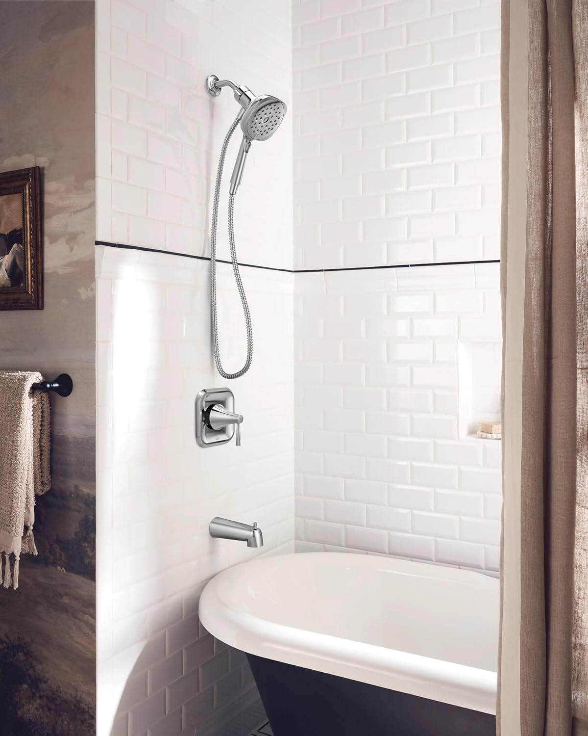 Moen Ronan Chrome Tub and Shower Faucet installed in a modern bathroom with white subway tiles and a freestanding tub
