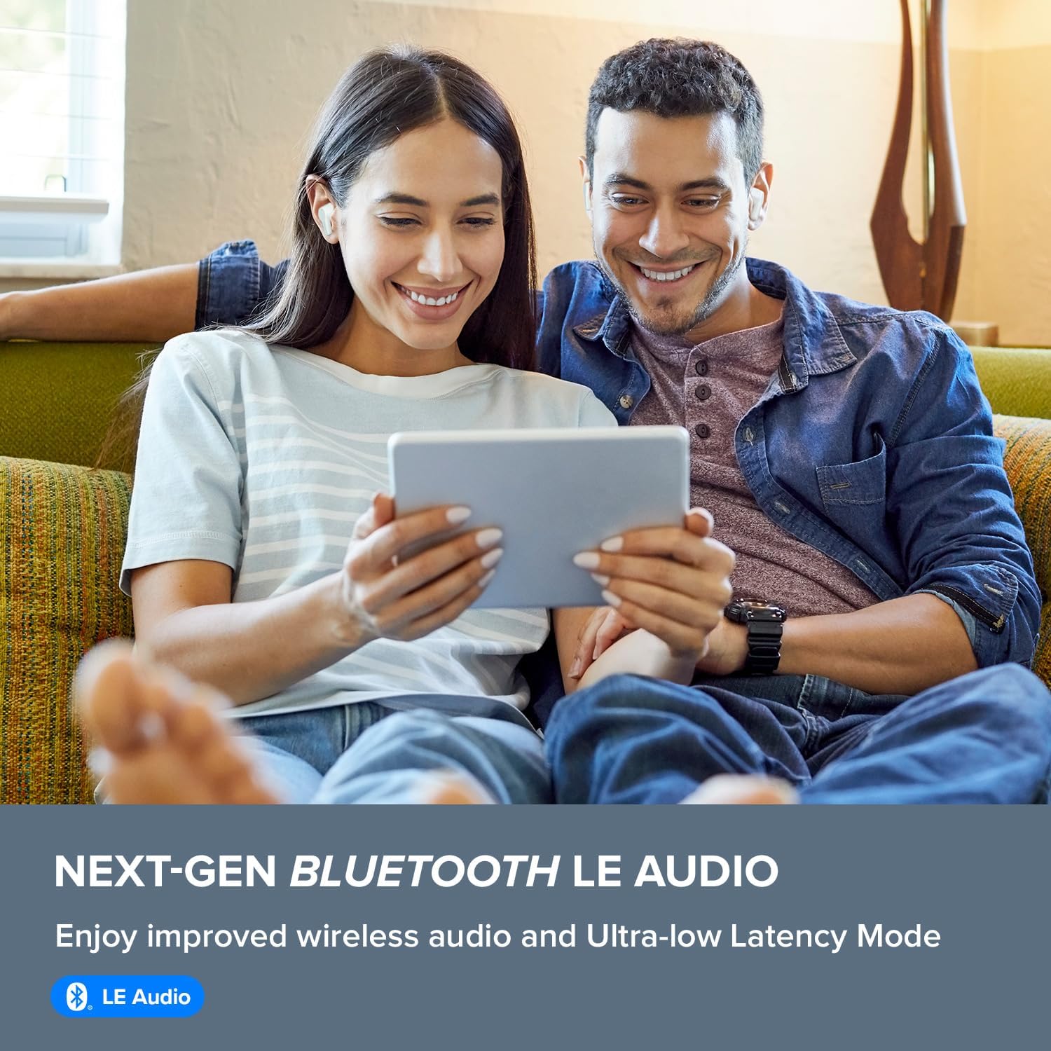 A couple smiling and looking at a tablet, both wearing Creative Zen Air Pro earbuds, illustrating the 'NEXT-GEN BLUETOOTH LE AUDIO' feature.