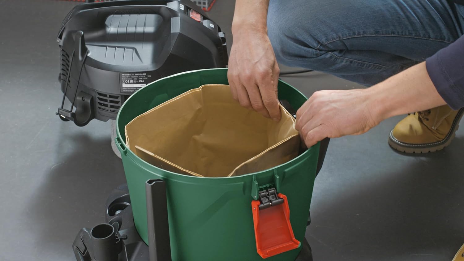 User utilizing the blowing function of the Bosch AdvancedVac 20 to clear leaves