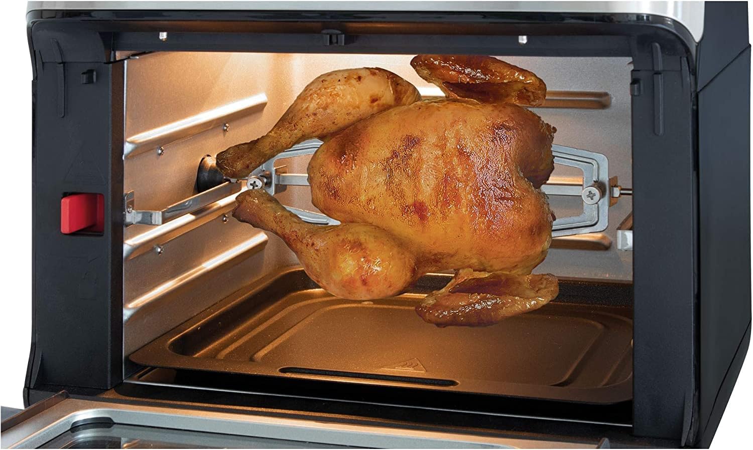 Whole roasted chicken on rotisserie spit inside the air fryer