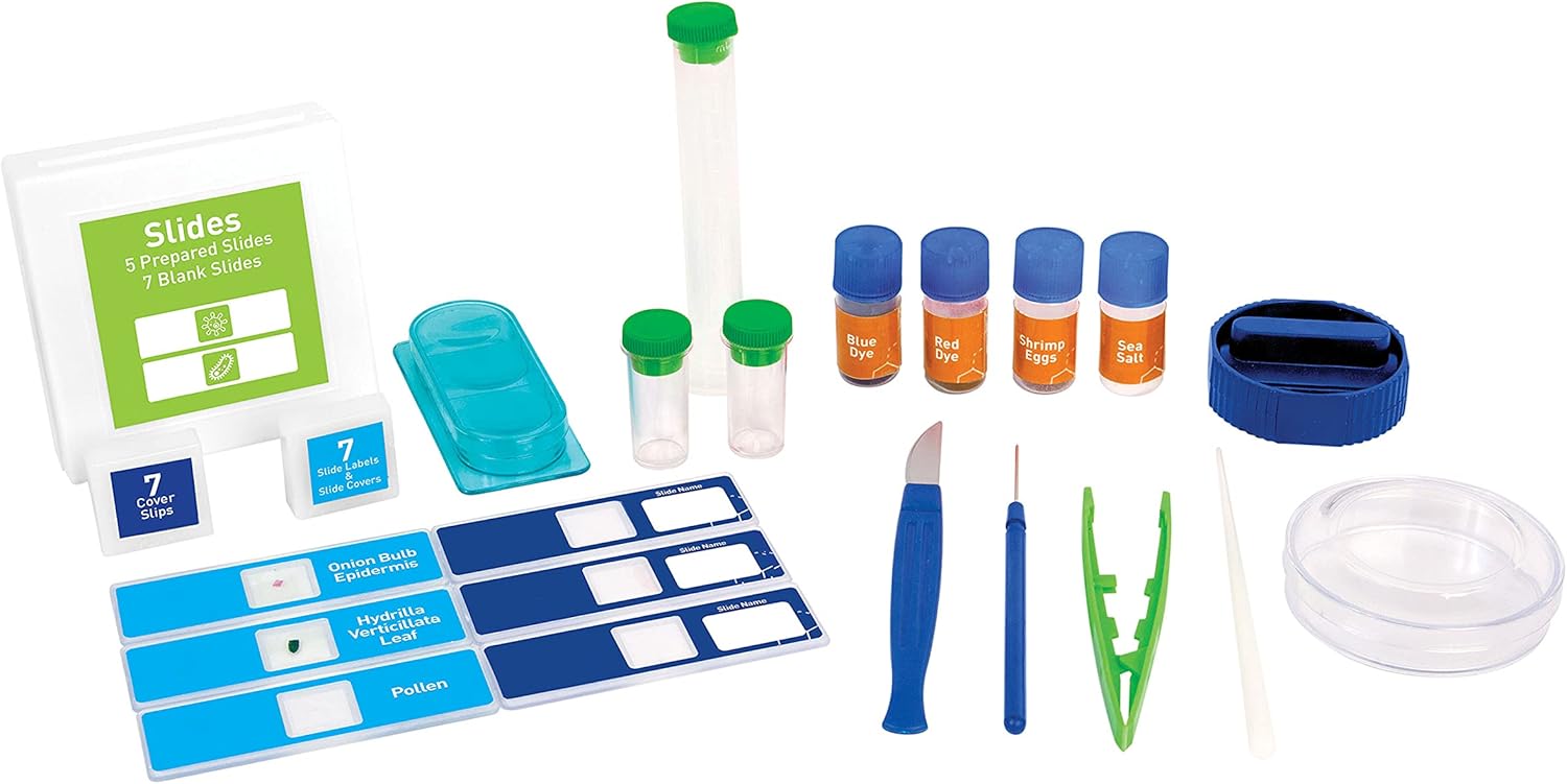 Primer pla view of the lab accessories included with the microscope, such as prepared slides, blank slides, cover slips, various dyes, shrimp eggs, sea salt, a petri dish, and small collection tools like tweezers and a scalpel.
