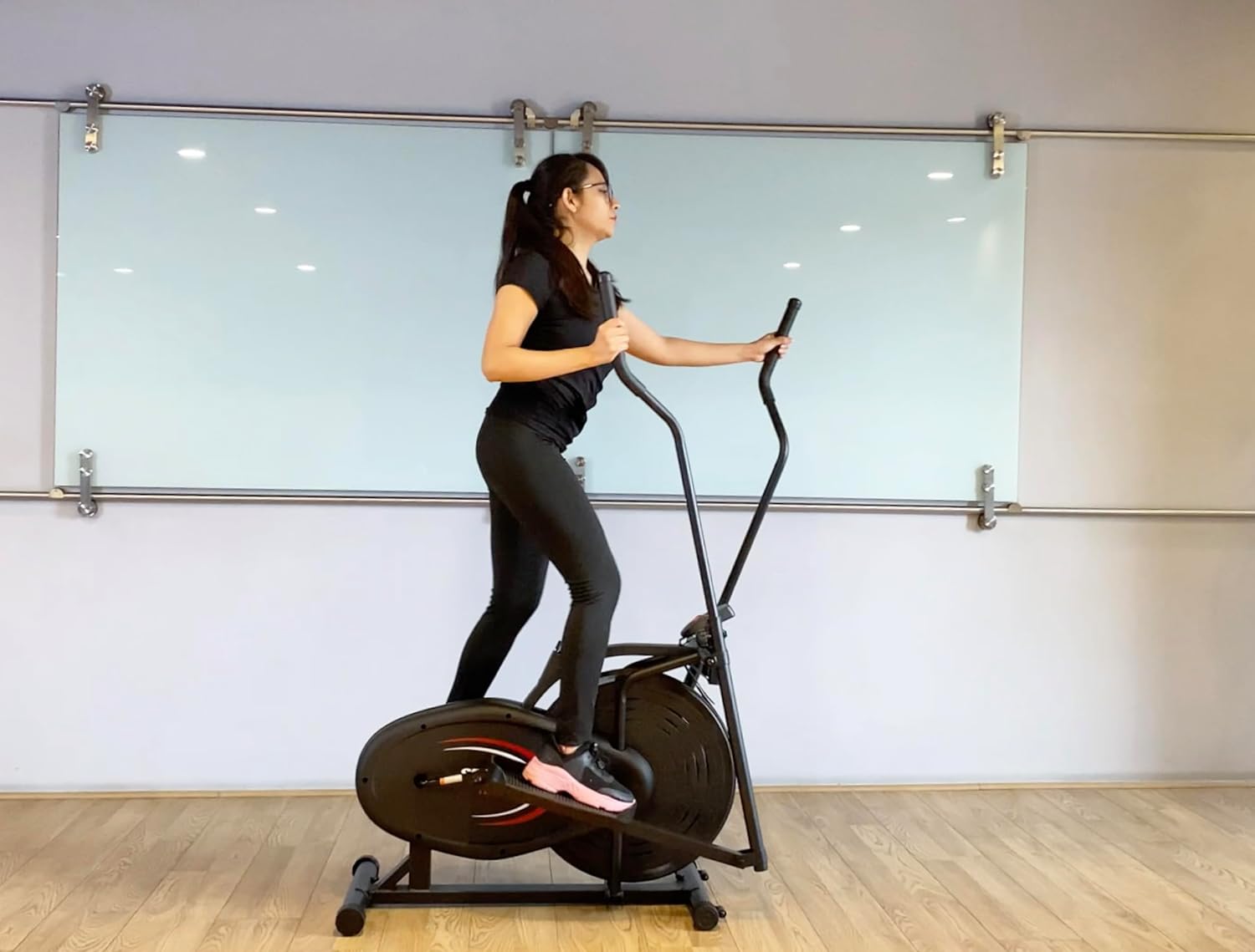 Hand adjusting the resistance knob on the elliptical.