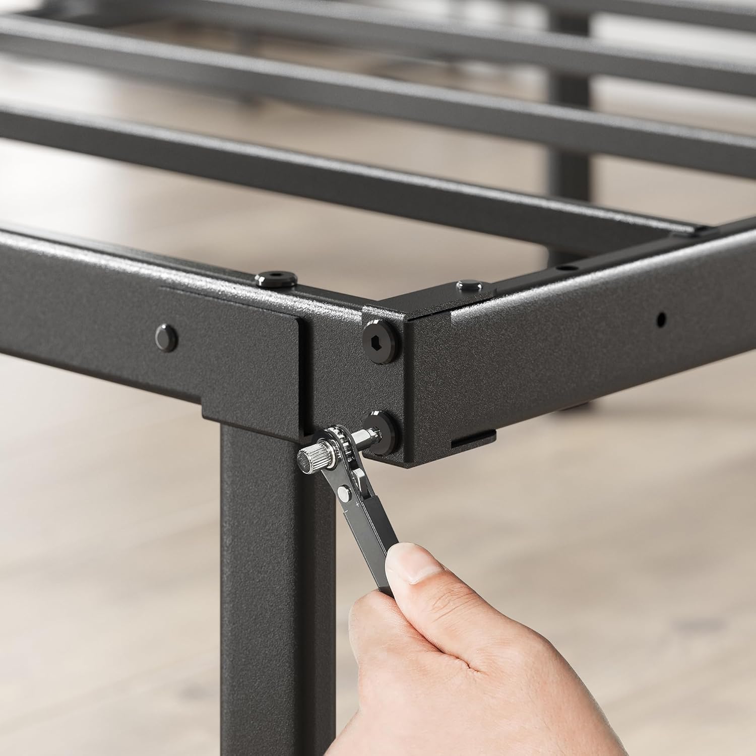 Close-up of a hand tightening a bolt on the Zinus bed frame during assembly