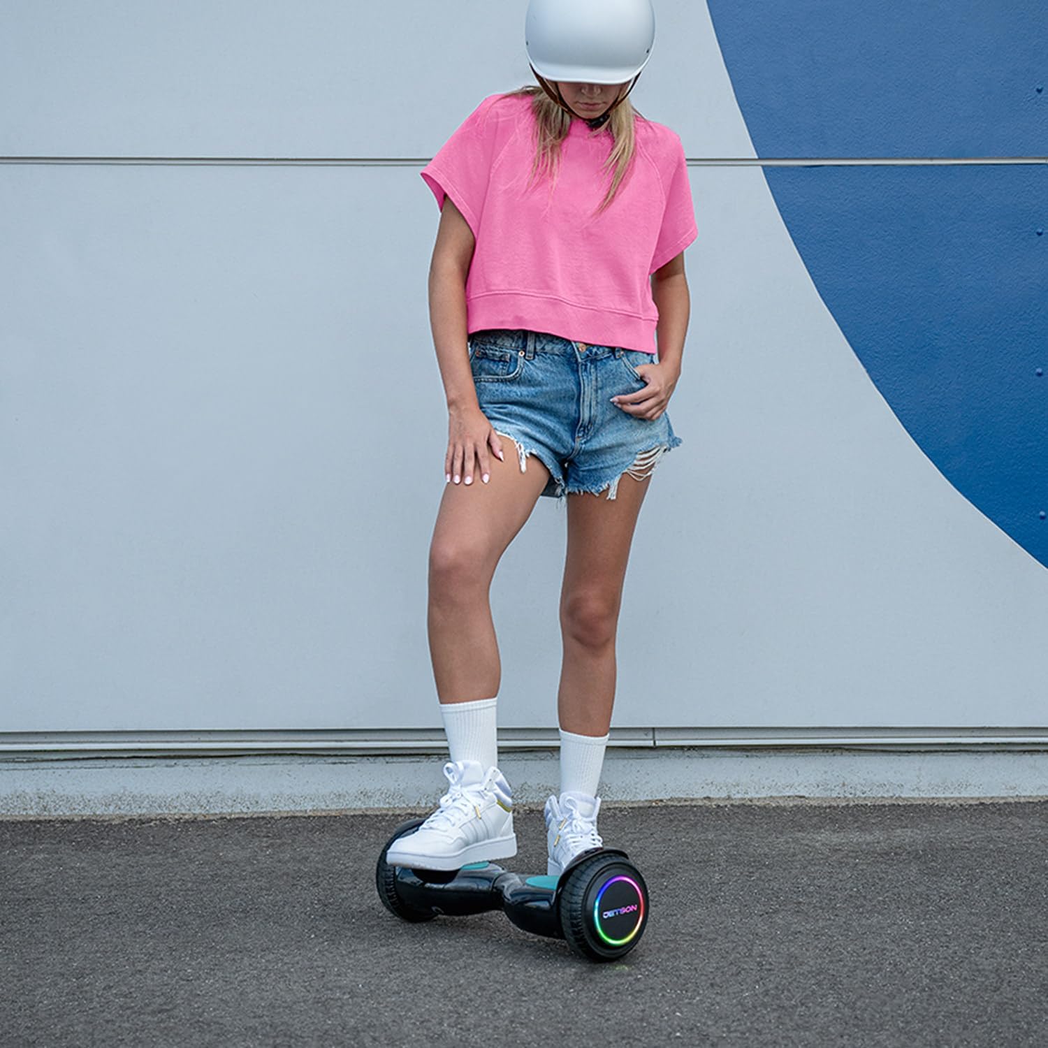 A young person wearing a helmet riding the Jetson All Terrain Hoverboard outdoors, demonstrating its use.