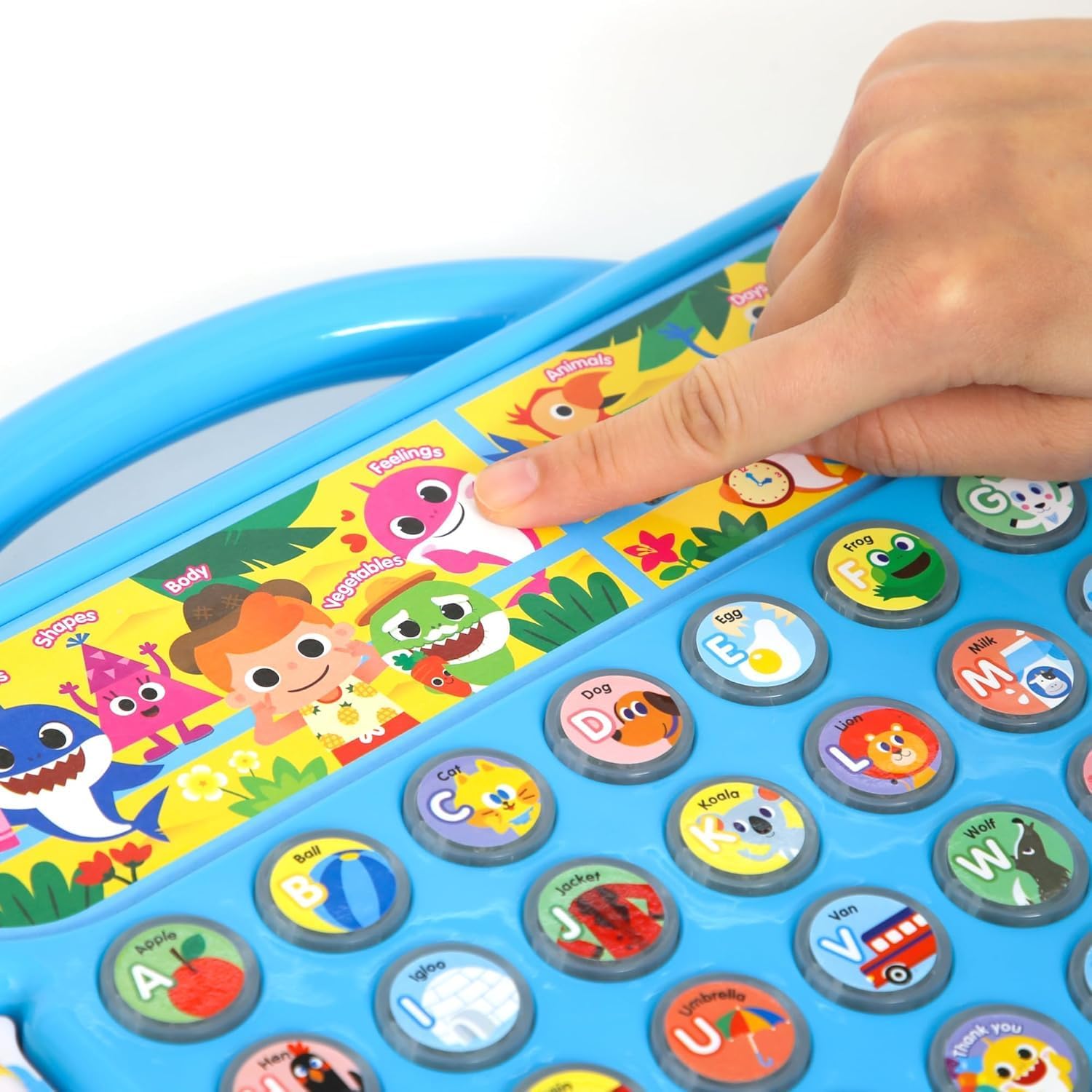 Close-up of a hand pressing one of the circular letter buttons on the Pinkfong Baby Shark ABC Alphabet Bus, showing the detailed illustrations on each button.