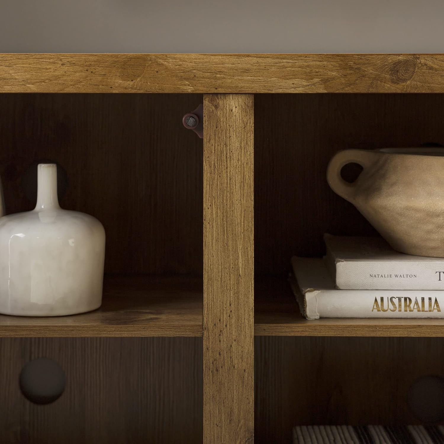 Interior view of the TV stand's central and side compartments with items stored