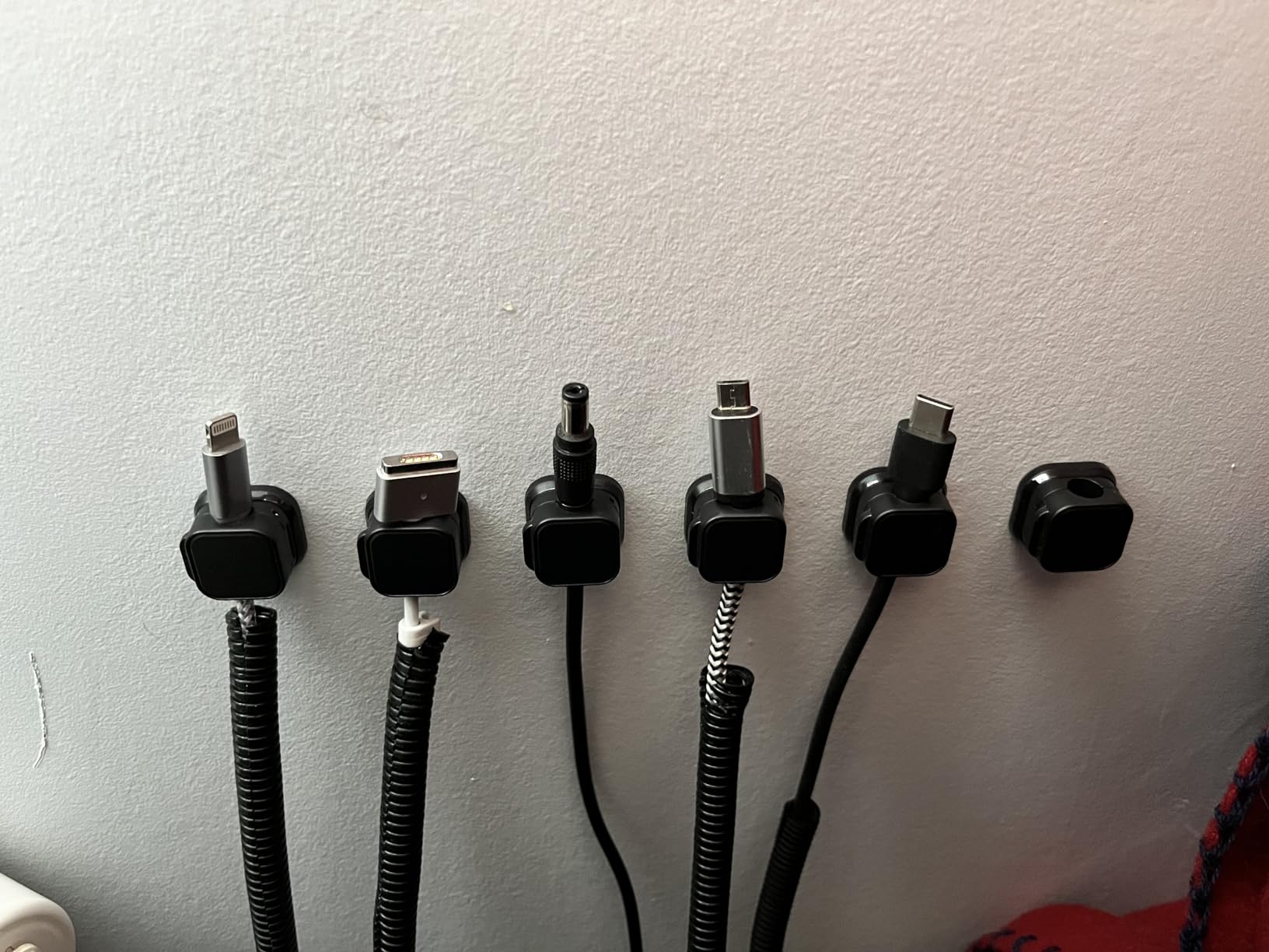 Six cable clips stuck to the wall