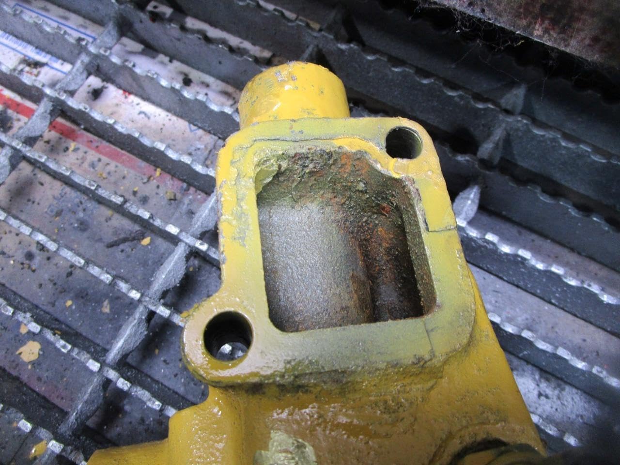 Close-up of the square opening at the top of the water inlet housing, showing internal surfaces and potential corrosion.