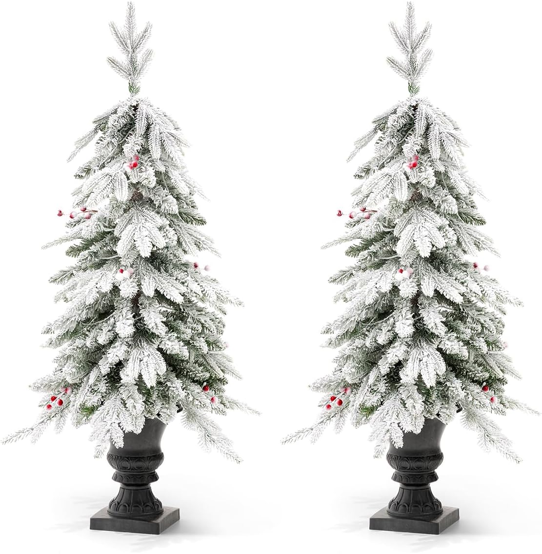 Two Glitzhome 4ft flocked Christmas trees with warm white lights and red berries, in urn bases, shown against a white background, similar to the previous image but with a slightly different angle.