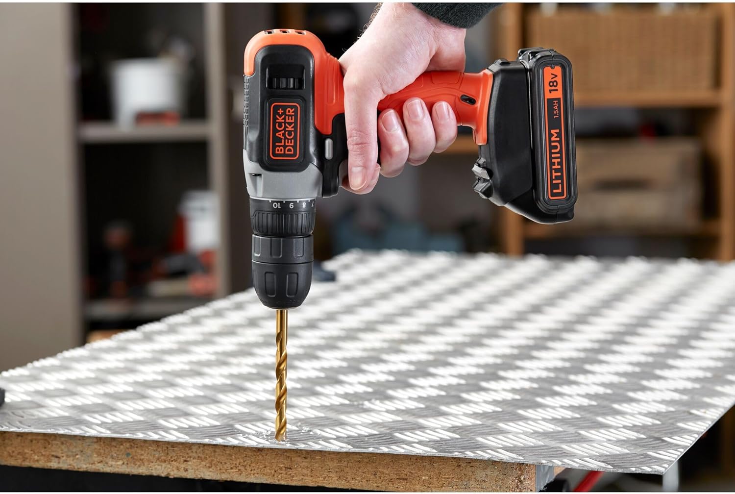 Person using the drill to bore a hole in a metal sheet.