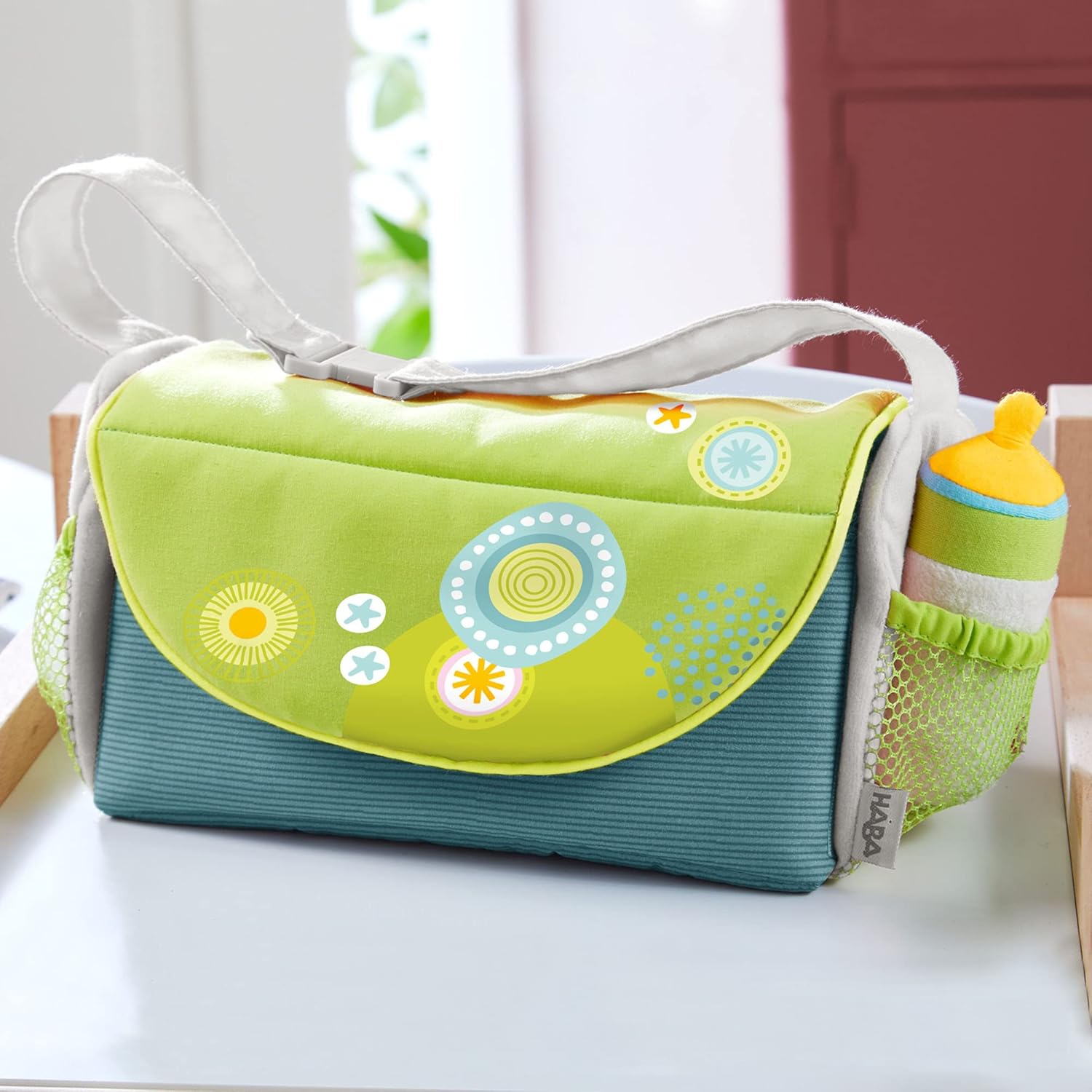 HABA Baby Doll Diaper Bag with Soft Bottle & Reusable Cloth Doll Diapers, Folds into Changing Mat, Summer Meadow Print Toddler Pretend Play Accessories for Ages 18 Months & Up