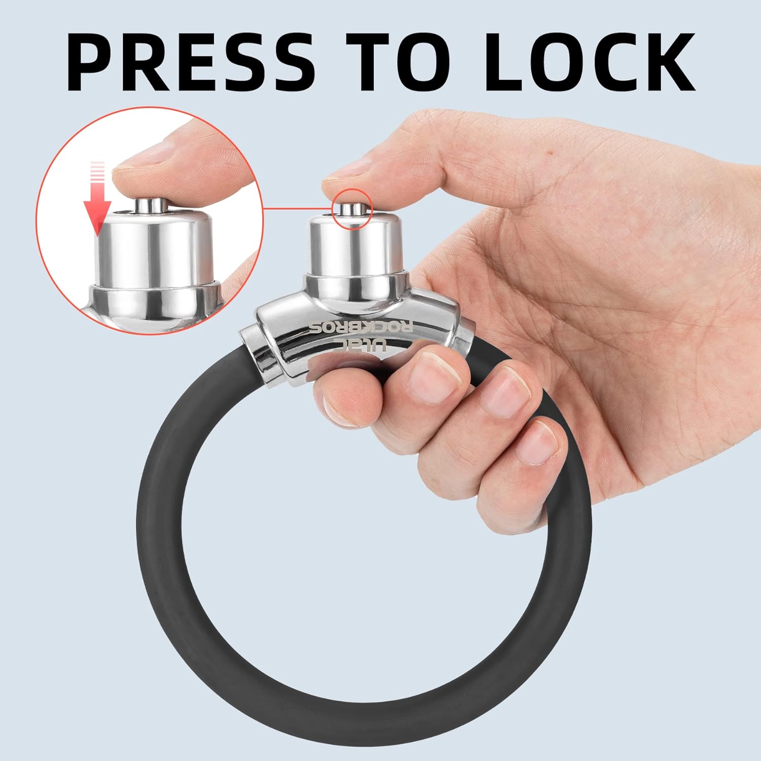 A hand pressing the latch of the ROCKBROS cable lock to engage the locking mechanism.