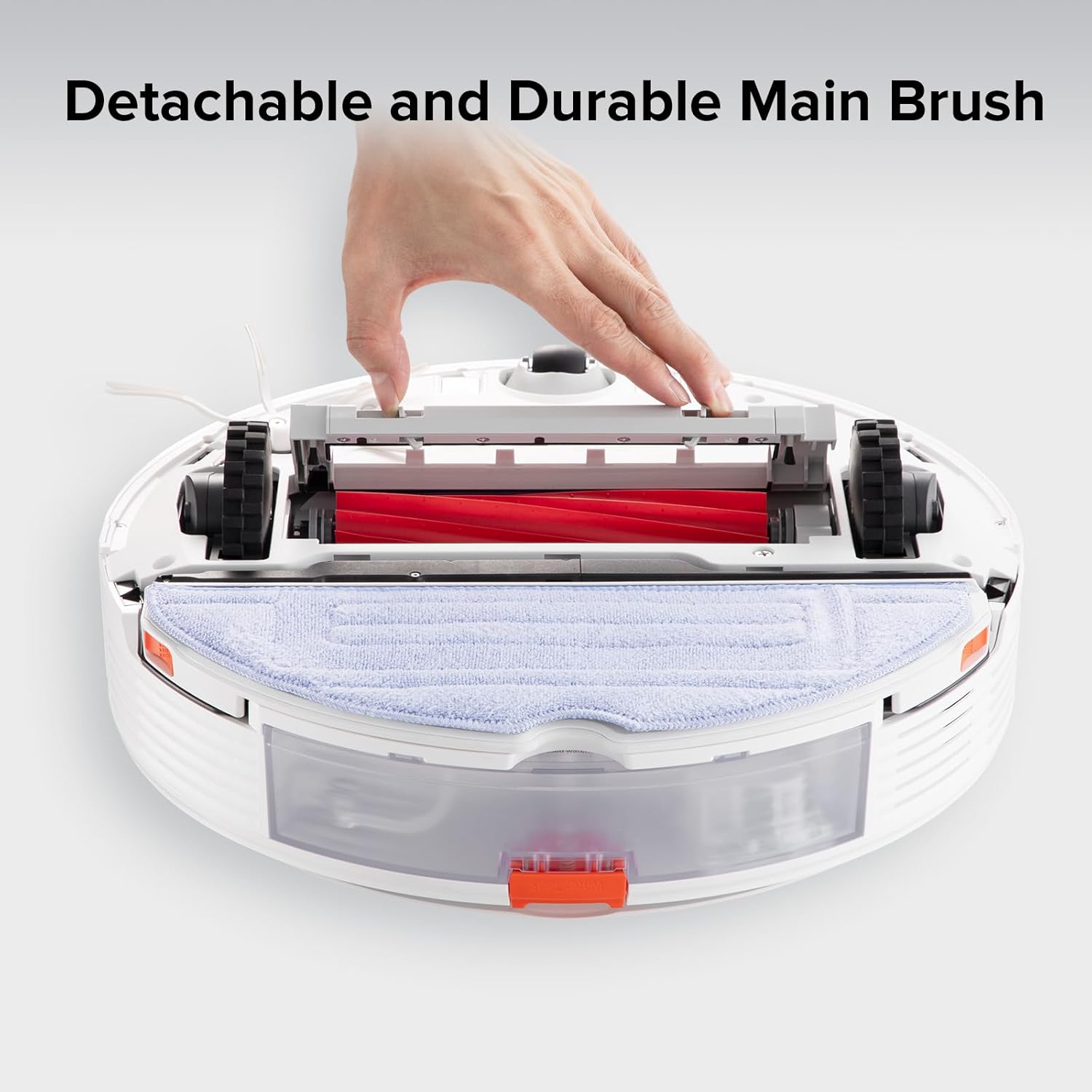 A hand demonstrating the removal and installation of the detachable main brush from a robot vacuum.