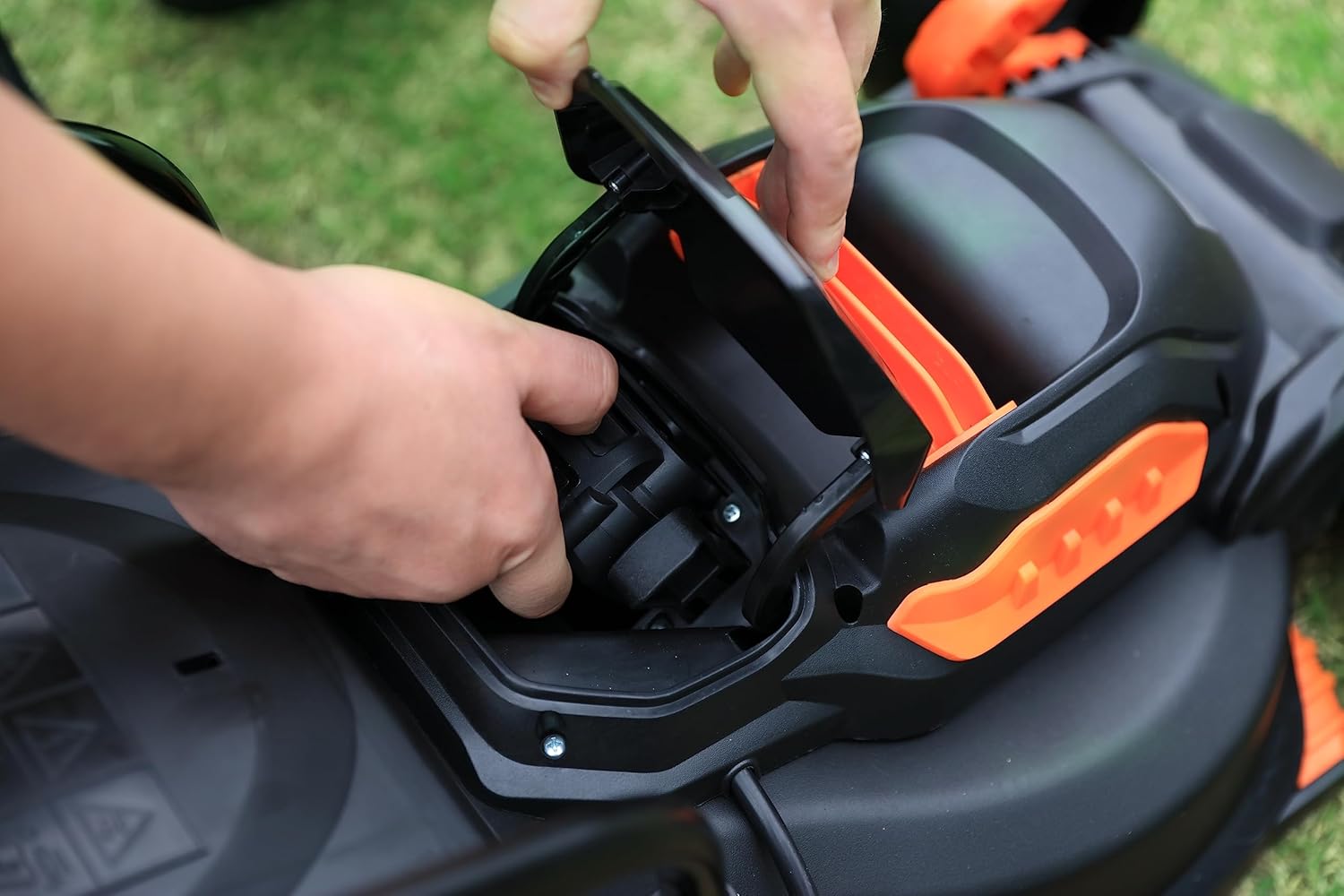 Hand inserting Yard Force battery into a power tool