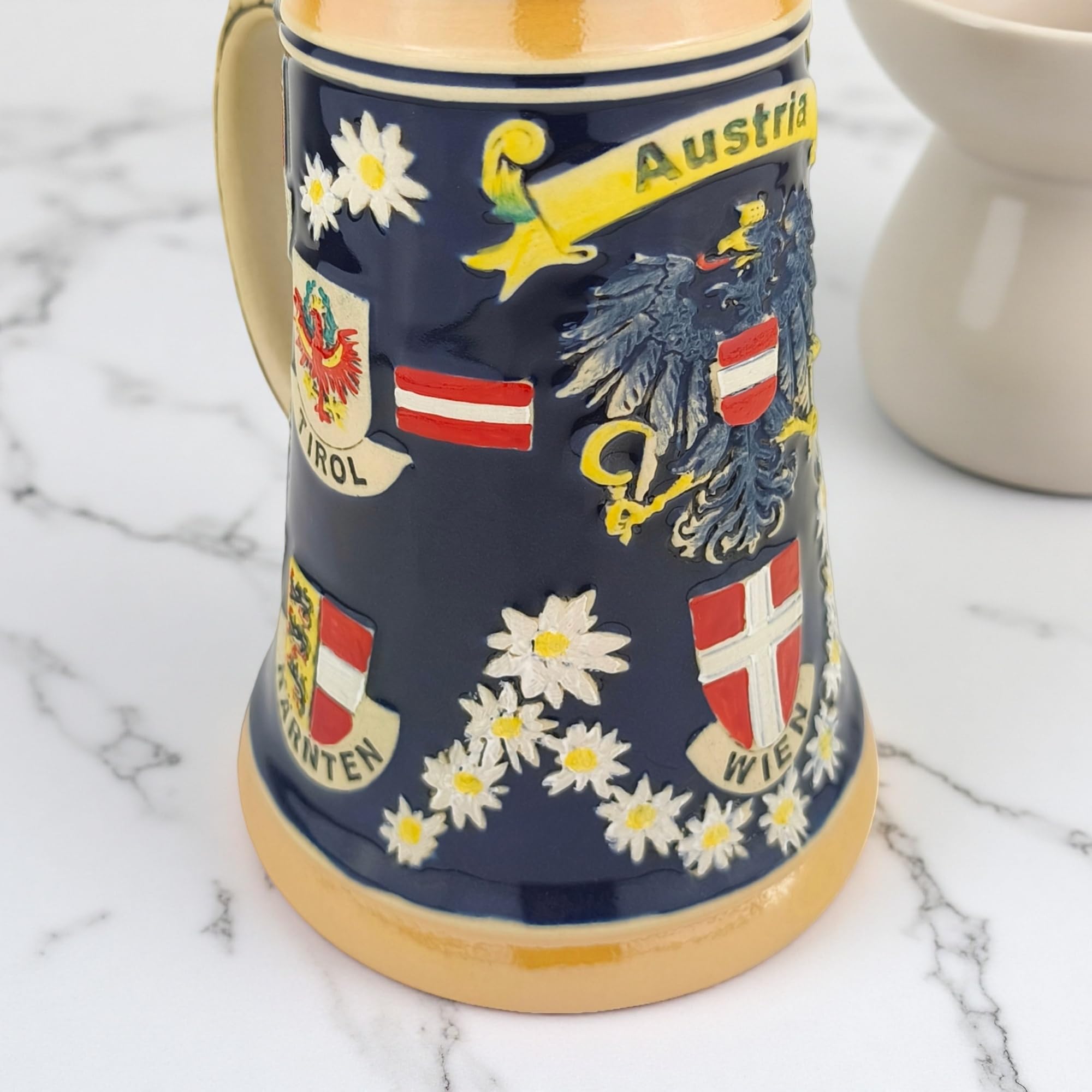 Bierkrug mit Deckel 0,7L mit Österreich-Motiv – Steinkrug mit Bundesländer-Wappen und Edelweiß-Dekor – Souvenir & Geschenkidee