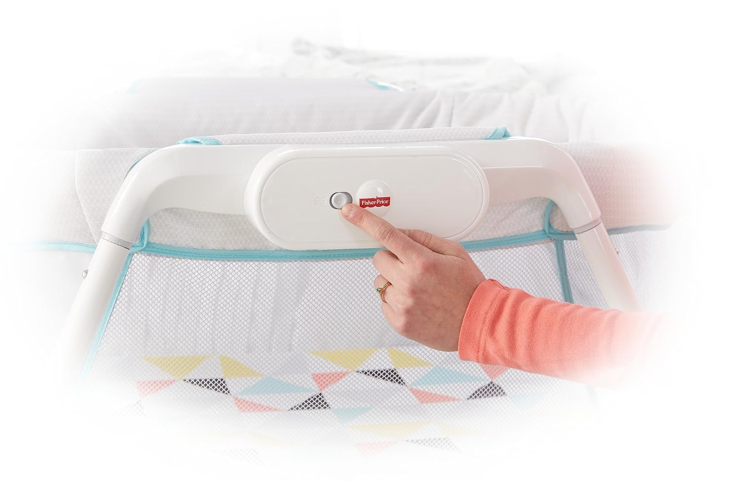 Hand pressing the vibration button on the bassinet