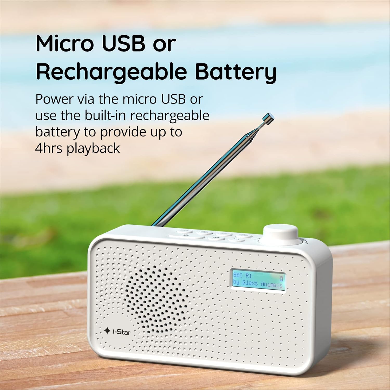 i-Star Portable DAB/DAB+/FM Radio being charged via a Micro USB cable, with a green outdoor background.