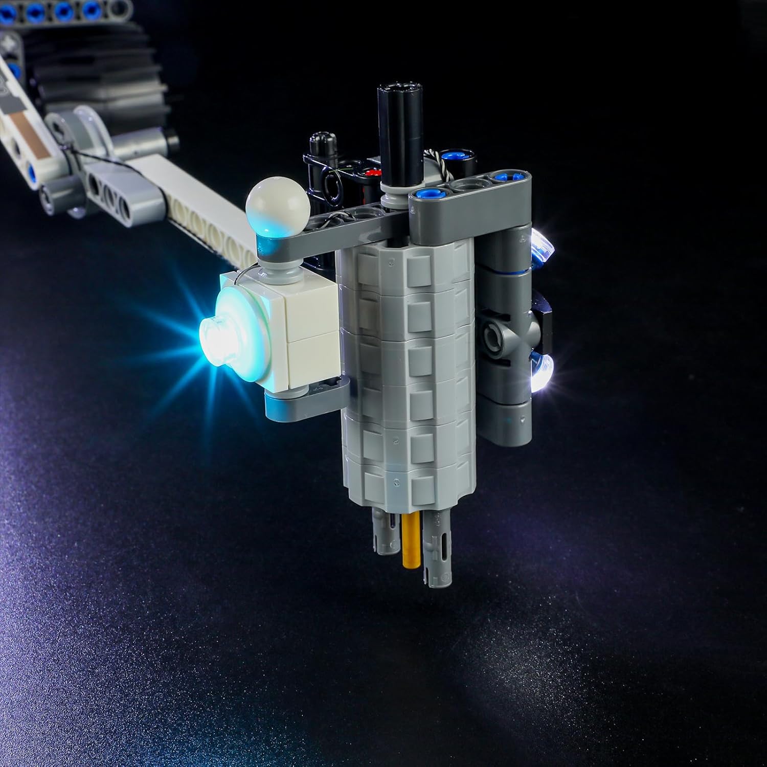 A close-up of a white LED light from the BRIKSMAX kit integrated into a section of the LEGO NASA Mars Rover Perseverance model, emitting a bright glow.