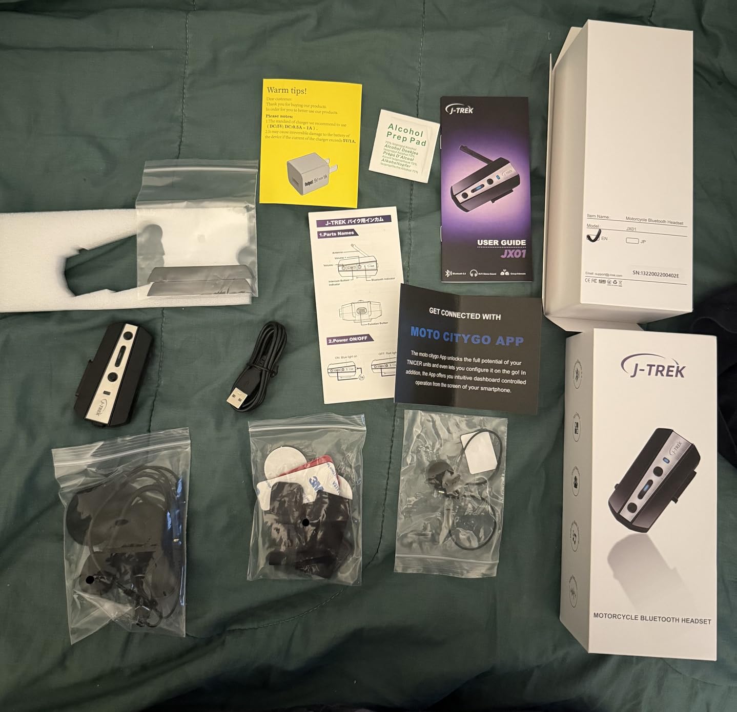 Image showing all items included in the J-TREK JX01 package, such as the headset unit, speakers, microphone, and various mounting accessories.