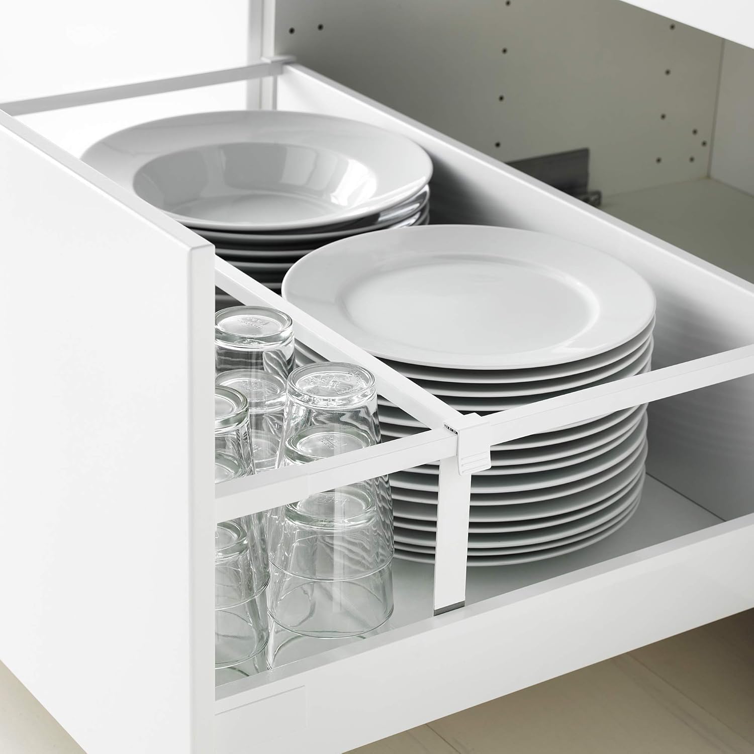 Open drawer filled with neatly stacked plates and glasses