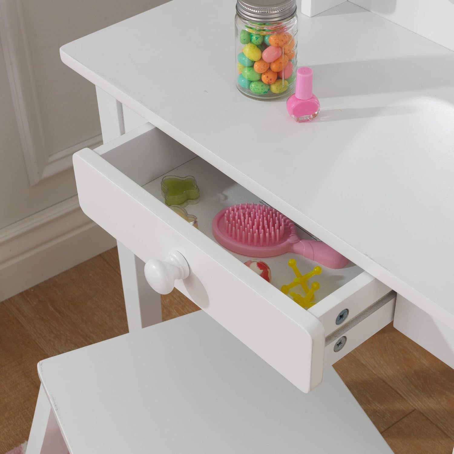 Close-up view of the vanity's drawer containing a brush and small toys