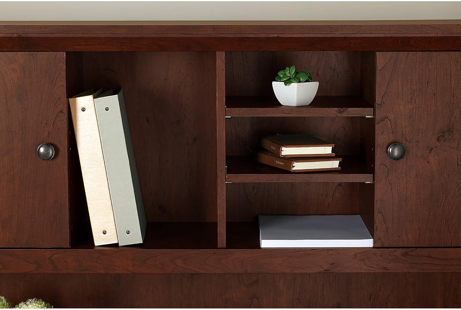 Close-up of the adjustable shelves within the hutch's open cubbies, demonstrating flexibility for different item heights.