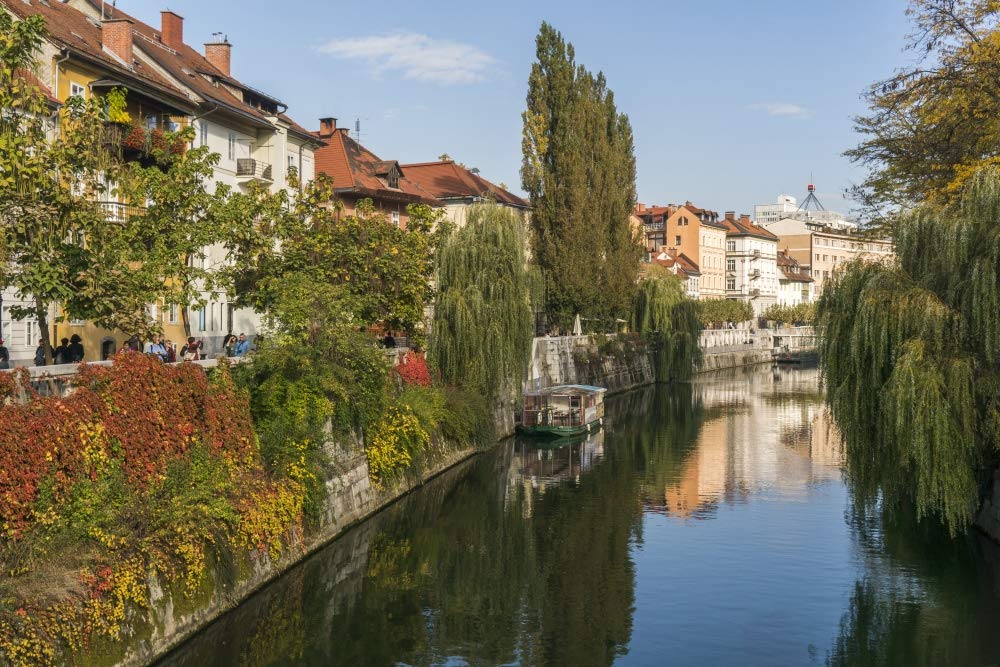 Slovenia, Ljubljana. Vines and trees provide a lush urban corridor along the Ljubljanica River. Poster Print by Brenda Tharp (18 x 24)