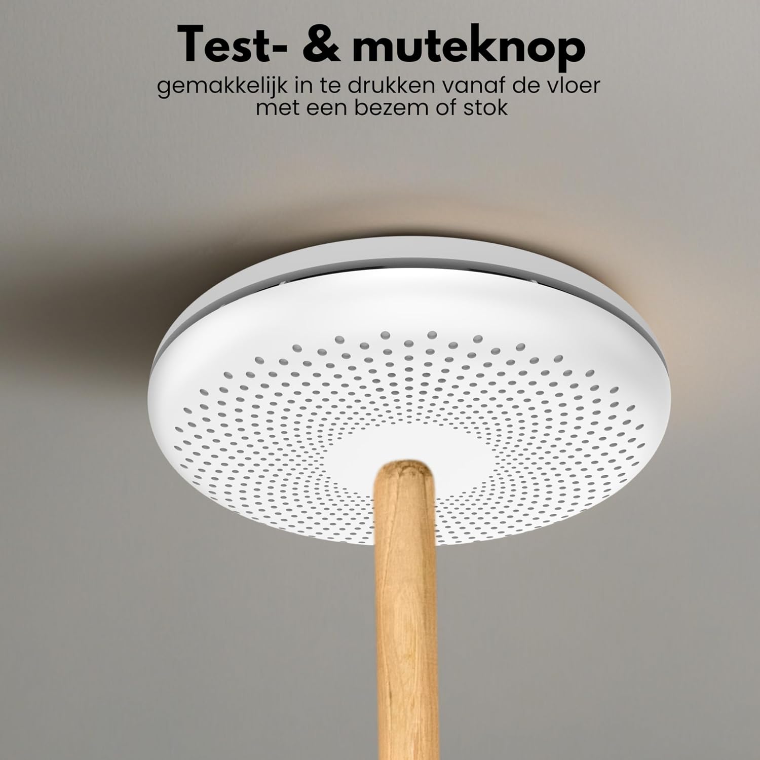 Aroha Safety Pro Combimelder on a ceiling, with a broomstick pressing the test/mute button