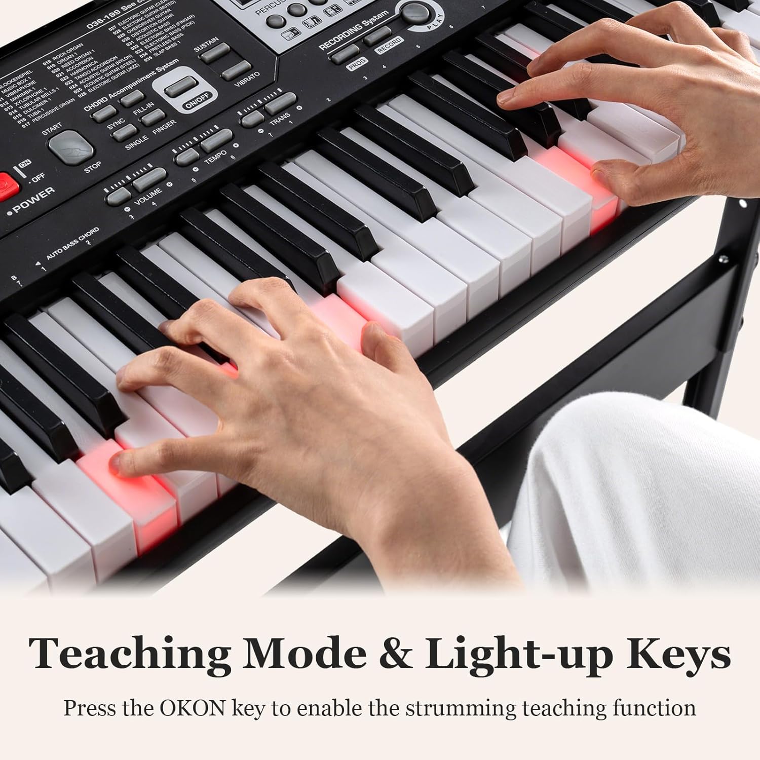 Close-up of hands playing the keyboard with lighted keys, demonstrating the teaching mode.