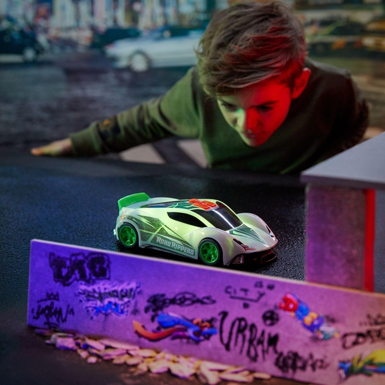 Child observing Nikko Road Rippers Color Wheels car in action