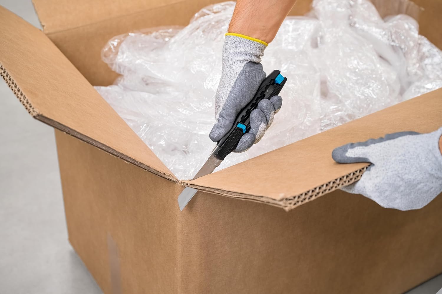 Person opening a cardboard box with SECUBASE 383