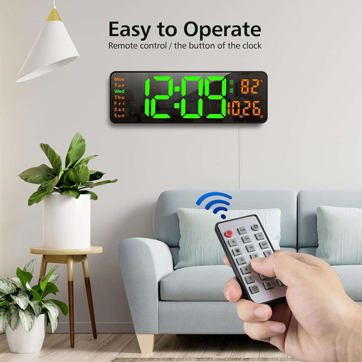 A hand holding the remote control, pointing towards the Zgrmbo 16-inch Digital Wall Clock mounted on a wall.