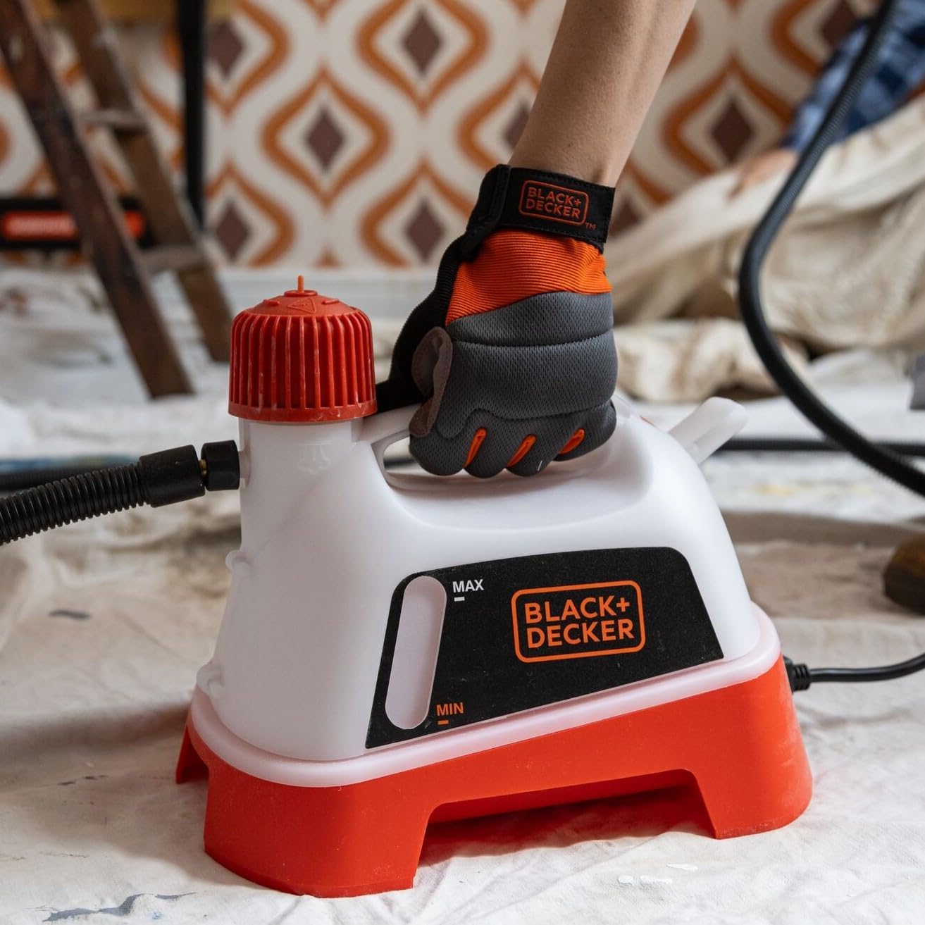 Close-up of the BLACK+DECKER wallpaper steamer unit, showing the water tank, cap, and hose connection.