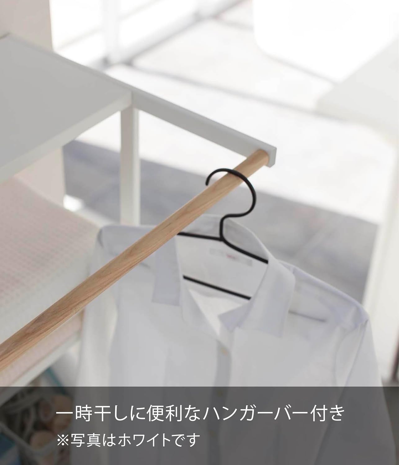 Close-up of the wooden hanger bar on the Yamazaki 2483 Laundry Shelf with a white shirt hanging from it.