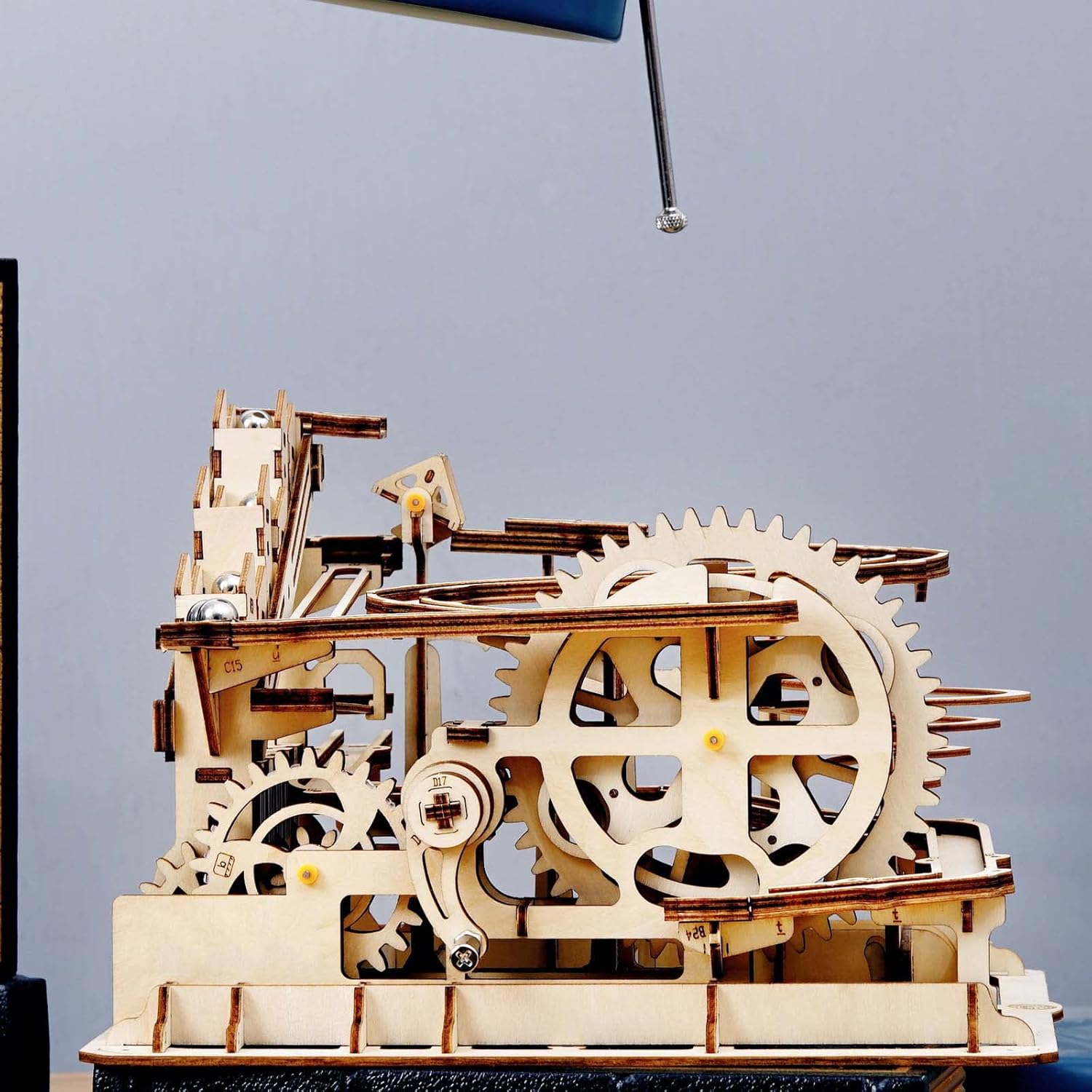 Close-up of the hand crank mechanism on the wooden marble run